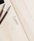 Sturdy 8 Pack R Shape Hitch Pins Made From Industrial Stainless Steel For Secure Mechanical Assembly And Fastening Lock Applications That Are Easy To Install And Super Durable For Any Heavy Duty Task on a wooden surface with beauty products.