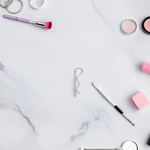 Heavy Duty Stainless Steel Cotter Pins With Wavy Design Secure Industrial Hitch Connections And Mechanical Fasteners That Never Slack Or Fail For Serious Projects on marble surface with makeup tools.