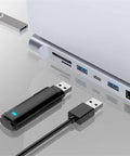 Slick 12 In 1 Type C Hub Docking Station With Crisp 4K Display, USB drives and ports on a silver laptop.