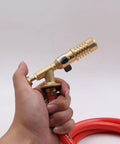 Premium Replaceable Propane Torch For Welding And Brazing With Self Ignition Lock in hand, showcasing ergonomic brass design and hose.
