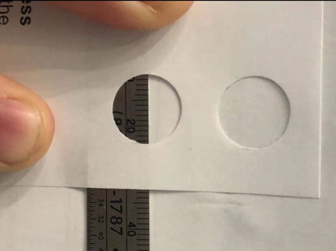 Close-up of 13mm round holes punched in paper using Hand Held Slot And Thirteen Millimeter Round Hole Punch Tool 2-In-1 Diy Puncher.