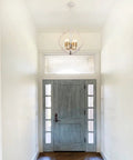 Modern Farmhouse 4 Light Wood Chandelier In Distressed White And Gold With Orb Globe Cage Pendant Lighting in foyer view