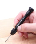 Pin Vise Hand Drill Set With 25 Micro Twist Drill Bits 0.5 To 3.0 Millimeter being held over wood for precise manual drilling.