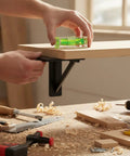 Person using a green Bubble Level Vial, Spirit Level on a wooden board, ensuring accurate leveling in a workshop.