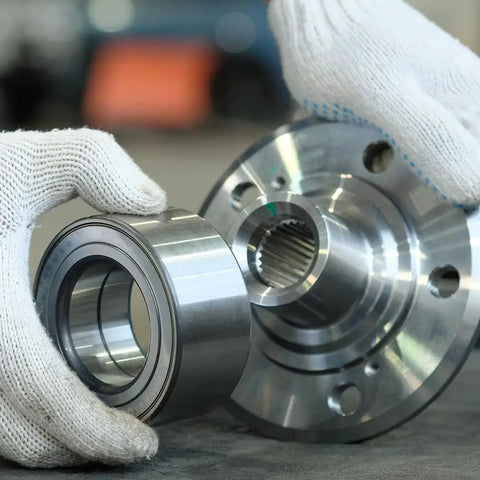 Gloved hands holding MR128-2RS Deep Groove Ball Bearing Set, 8mm ID, 12mm OD, 3.5mm Thick, Double Sealed Chrome Steel, next to machinery