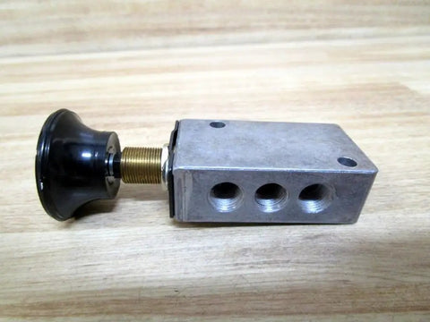 One Eighth Inch Inlet Two Position Mechanically Operated Valve With Four Way Control And Palm Actuator side view showing metal body and black palm actuator