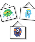 Three framed colorful monster illustrations for kids' rooms, featuring unique designs and vibrant colors, hanging on a white wall.
