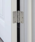 Heavy Duty Satin Nickel Interior Door Hinges 2 Pack Steel Construction With Slick Radius Corners For Hassle Free Residential Doors And Durable Replacement Gear That Seriously Stands Up on a white door edge.