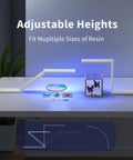 Badass 54W Wireless UV Resin Light With Adjustable Folding Stand illuminating resin art pieces on a table, showing height variations.