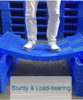 Person standing on blue interlocking plastic pallet storage pad with breathable drainage grids