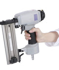 Smooth Operator Pneumatic Brad Nailer Featuring Low Noise Air Drive And Spring Buffer Switch For Knocking Out Trim Work And Fine Woodworking Tasks Around Your Space, held in hand with metal frame.