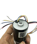 Robust 12V Or 24V DC Brushless Gear Motor With High Torque For Custom DIY Robotics And Automation Projects That Deliver Smooth Power At Speeds Ranging From 8 To 1040 RPM Every Single Time held in hand with visible wiring.