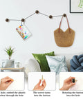 Rustic Forest Mushroom Cabinet Knobs 4 Pack shown on wall holding a bag and calendar, with decorative plants nearby.