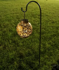 Two Pack Adjustable Shepherd Hooks With Heights Of Thirty One Twenty Four And Sixteen Inches Heavy Duty One Half Inch Thick Black Outdoor Hangers For Lanterns Solar Lights Bird Feeders Planters Wedding Aisles And Yard And Patio Garden Decor with a lit lantern hanging in yard.
