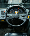 Interior view of a forklift cockpit with steering wheel and control panel for stability in operations using Solid 3 Piece Fork Positioner Limit Pins With Large Base And Reinforced Structure For 3 Ton Forklift Spring Loaded Plunger Locks That Keep Things Stable And Handle Heavy Dues Like A Boss.