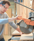 Man wearing 100 Pairs Clear Safety Glasses Bulk For Group Use In Lab And Workshop, operating a circular saw.