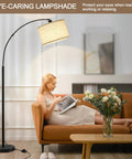 Woman reading under Arched 71 Inch Floor Lamp With Fully Dimmable 0 To 100 Percent Light And Foot Pedal Switch Adjustable Head in living room