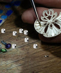 Slick Heavy Metal Threaded Pin Keepers And Locking Pin Backs Set For Brooches Jewelry Making Findings on a workbench.