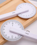 360 Degree Rotating Quilting Ruler With Scaled Roller Wheel For Precise Pattern Making And Angle Measurement on wooden surface.
