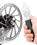 Close-up of hand using Bike Disc Rotor Alignment Tool For No Fuss Rotor Truing And Quick Bike Wheel Alignment on a rotor.