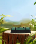Multi Functional Chef Knife Roll Bag With Pockets And Handle for kitchen and outdoor camping on tree stump in lush setting.