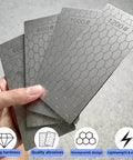 Hand holding diamond sharpening stones with honeycomb design, part of the Fourteen Pcs Diamond Sharpening Stone Set With Angle Guide And Leather Strop, Whetstone Honeycomb Plate With Non Slip Base For Pocket Knives And Scissors, Grit Range 80 To 3000.