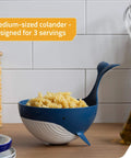 Pastail Medium Whale Shaped Pasta Colander For Draining Pasta Vegetables And Fruit filled with pasta, stands on fins for hands-free use