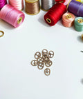 Dope 150Pcs Mini Buckle Set Alloy Tiny Buckles For DIY Doll Clothes Sewing Crafts With Silver Black And Bronze Colors on table