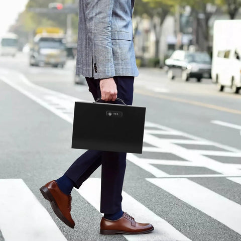 Person walking with Keep Your Stuff Locked Down With This Built Tough Fireproof Lock Box Featuring Dual Combo And Key Security Heavy Duty Metal Document Safe Portable Carry Handle Rock Solid Double Locked Design Black in hand.