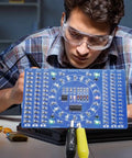 Person using DIY Soldering Practice Kit For SMD SMT Welding Training Board EK7026 With Water Lamp Circuit, blue PCB visible