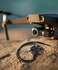 Pro Grade Brushless Drone Motor Alloy Construction Built To Last With 1300KV For 7 Inch Racing Drones next to a drone on a rock