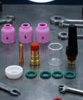Heavy Duty Tig Torch Consumables Kit With Copper Collet Body And Clear Cup For Clean Welds. Ceramic nozzles and replacement parts laid out.