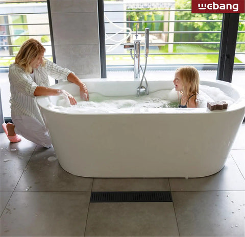 Woman and child in bath near 12 Inch Linear Shower Drain With Capsule Pattern Cover And Accessories, Matte Black Rectangular Floor Drain
