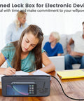 Girl studying with Heavy Duty Timed Lock Box That Slaps Your Phone Up for 30 Days Max Phone Jail on desk.