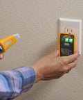 Person using 4 In 1 Breaker Finder, NCV Detector, Socket Tester And LED Flashlight on a wall outlet for circuit and voltage testing.