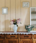 Rustic wooden cabinet with vase and flowers, showcasing 45 Pack Matte Black Stainless Steel Cabinet Pulls 7.38 Inch Length With 5 Inch Hole Center Dope Modern Kitchen Drawer Cupboard Handles For Cabinets Easy Install And Lasting Finish.
