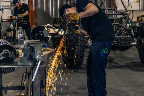 Close-up of a worker using Heavy Duty 1 HP Workhorse Industrial Belt And Bench Grinder Combo Featuring Multitool Attachment for metal shaping.