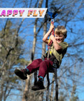 Child enjoying Backyard Zipline Kit For Kids And Adults With Stainless Steel Spring Brake in a sunny garden setting.
