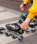 Person adjusting inline skate with Inline Skate Replacement Wheels With ABEC 9 Bearings And Floating Spacers For 72mm And 76mm Skates 85A