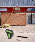 T Shaped Horizontal Bubble Level 2 Way For Spirit Level With Fluorescent seen beside a red level on a brick surface.