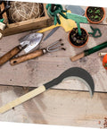 Long Handle Manganese Steel Hand Scythe For Weeding And Uprooting In The Garden with wooden handle and sharp blade on wooden table