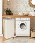 100L Collapsible Laundry Basket With Lid Waterproof Oxford Fabric Bamboo Frame placed beside a washing machine