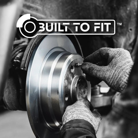 Centric 121.61087 C-Tek rear brake rotor being installed, metallic silver rotor with hub, gloved hands