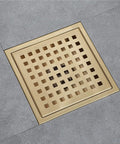 No Sweat Six Inch Square Shower Drain With Slick Brushed Black Coating Rock Solid Stainless Steel Body Quick Lift Removable Grate Setup Sweet Hair Catching Clog Deflector in gold finish.