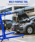 Grease Monkey Approved Folding Engine Hoist With Adjustable Telescopic Boom in garage near open car hood.