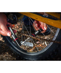 Using compact bar end bicycle tool kit with chain tool spoke wrench tire plugs hex torx and phillips bits for emergency repair.