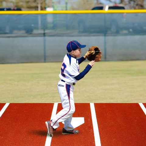 Youth player on a Baseball Batting Mat 10 Ft By 3.8 Ft Inlaid Home Plate Turf Hitting Mat With Carry Strap Non Slip Backing For Cage Indoor Or Outdoor Use Regulation Size For Left Or Right Handed Batters Brown, holding a glove.