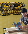 Man using a tool with a Power Tool Organizer Wall Mount For Garage Storage holding drills and tools on a pegboard wall.