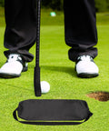 Golfer uses All In One Adjustable Mini Golf Putter Set With 8 Practice Balls on putting green, close-up of putter and ball near hole.