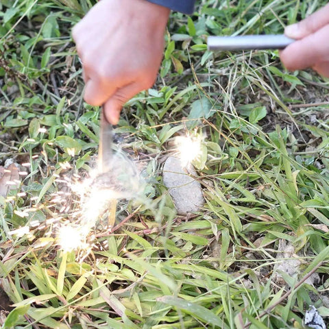 Person using 3/8 Inch By 4 Inch Drilled Survival Ferro Rod Flint Fire Starter With Toggle Lanyard Hole for campfire ignition